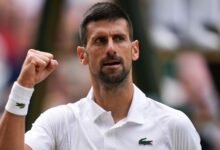 Novak Djokovic shakes hands with an injured Lorenzo Musetti at the net.